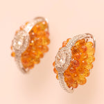 Load image into Gallery viewer, Oval Cluster Orange Sapphire Halo Huggie Earrings
